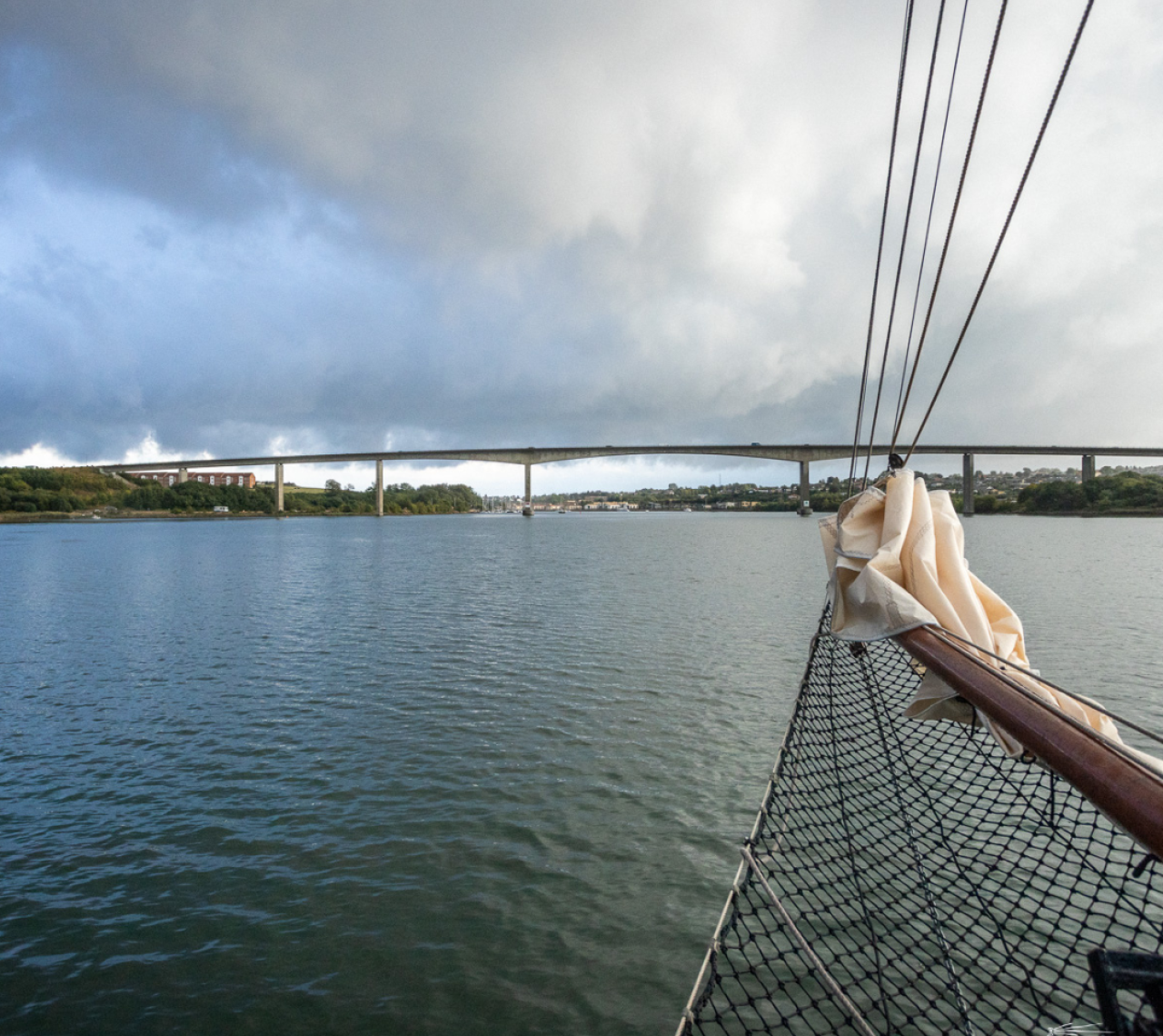 Klüverbaum eines historischen Segelschiffs: während Fahrt Richtung einer Brücke