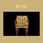 Ein Stuhl und eine Beschriftung „Hot Seat“,